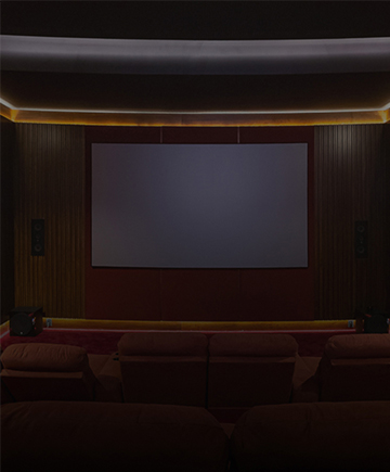 Permita-se a uma experiência única Sala de cinema residencial com sofás e poltronas confortáveis, iluminação embutida e tela grande.